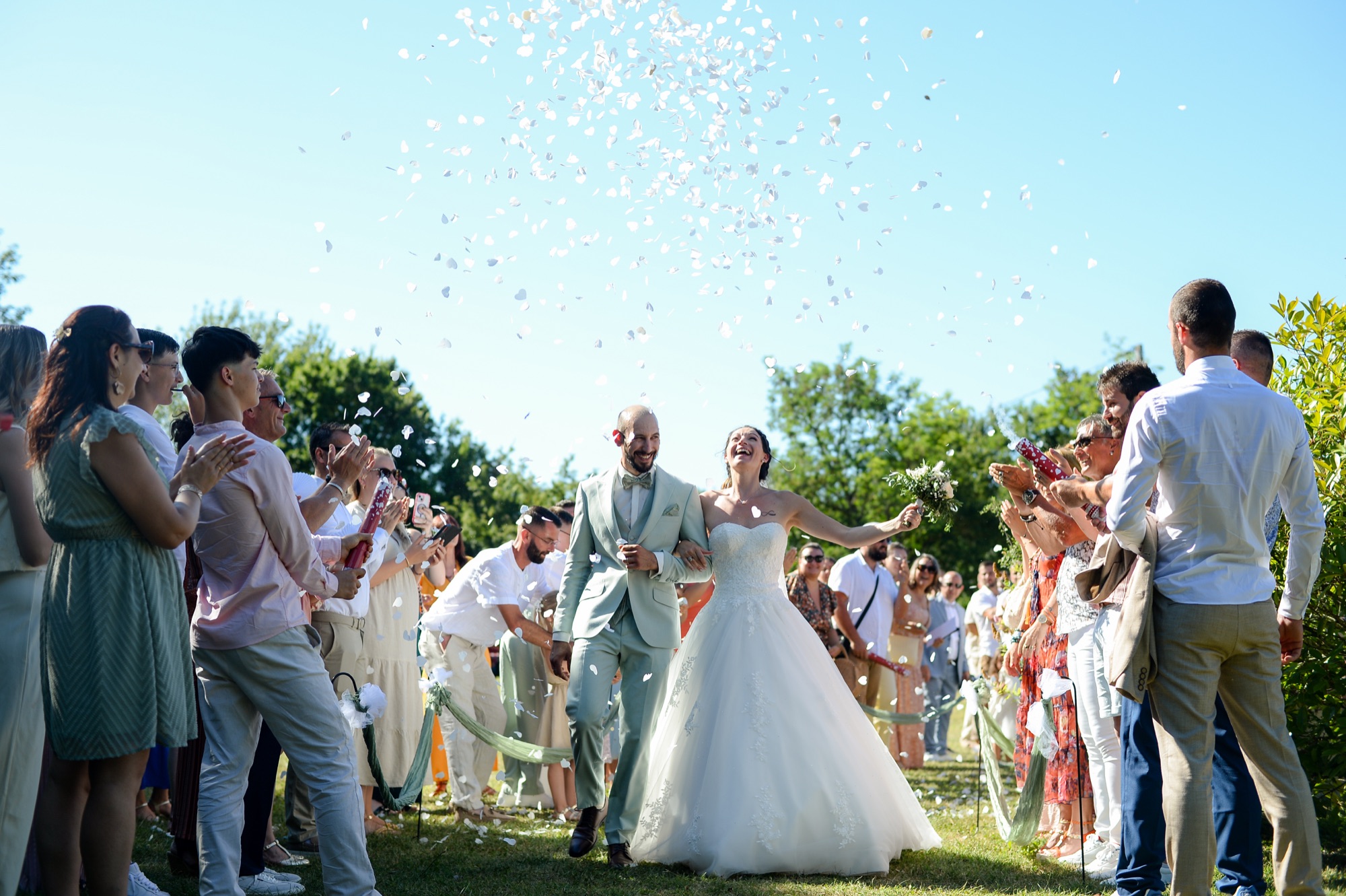 Les mariés sous une pluie de confettis, tout sourire